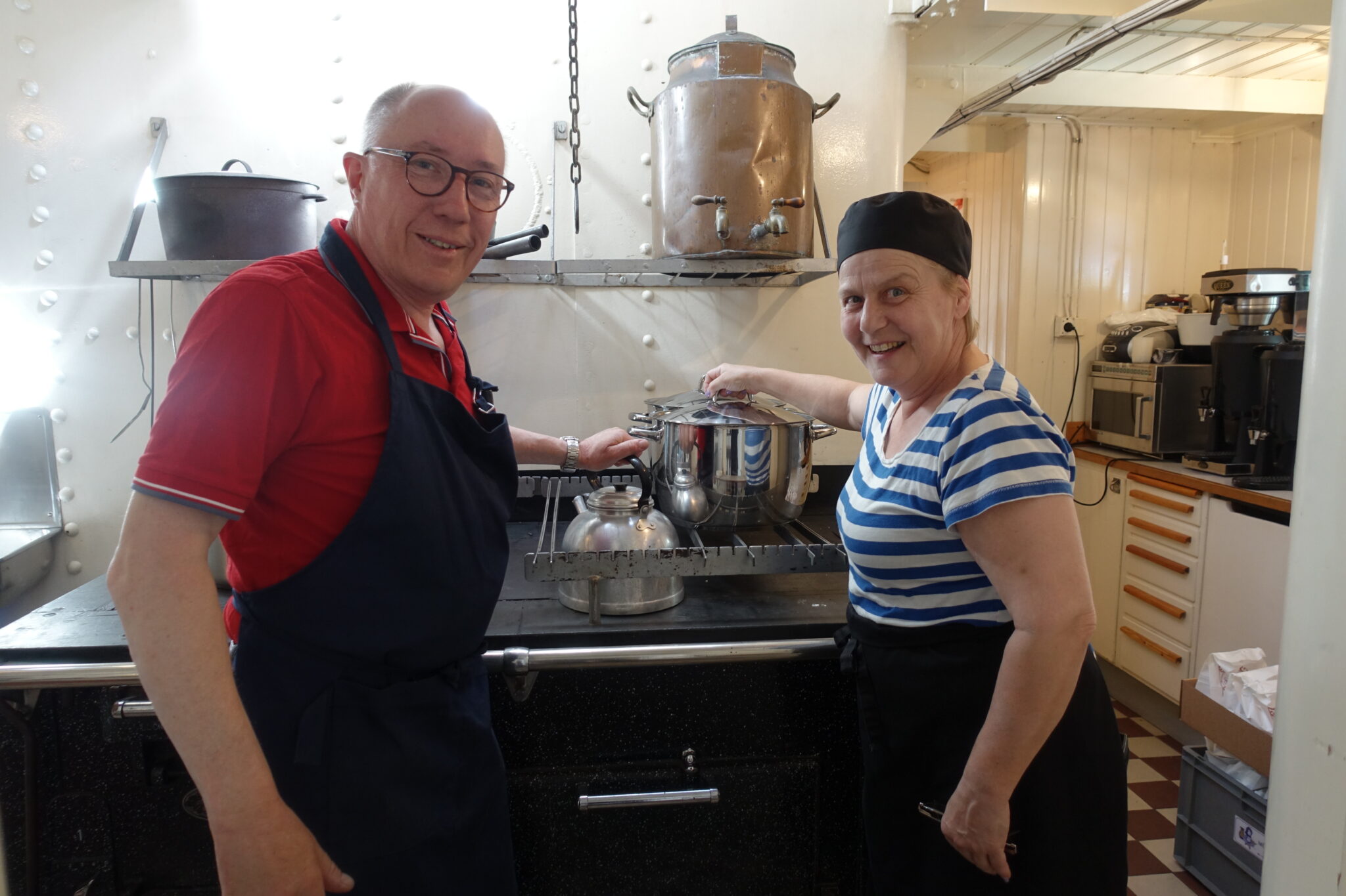 En man och en kvinna framför en ålderdomlig koksspis